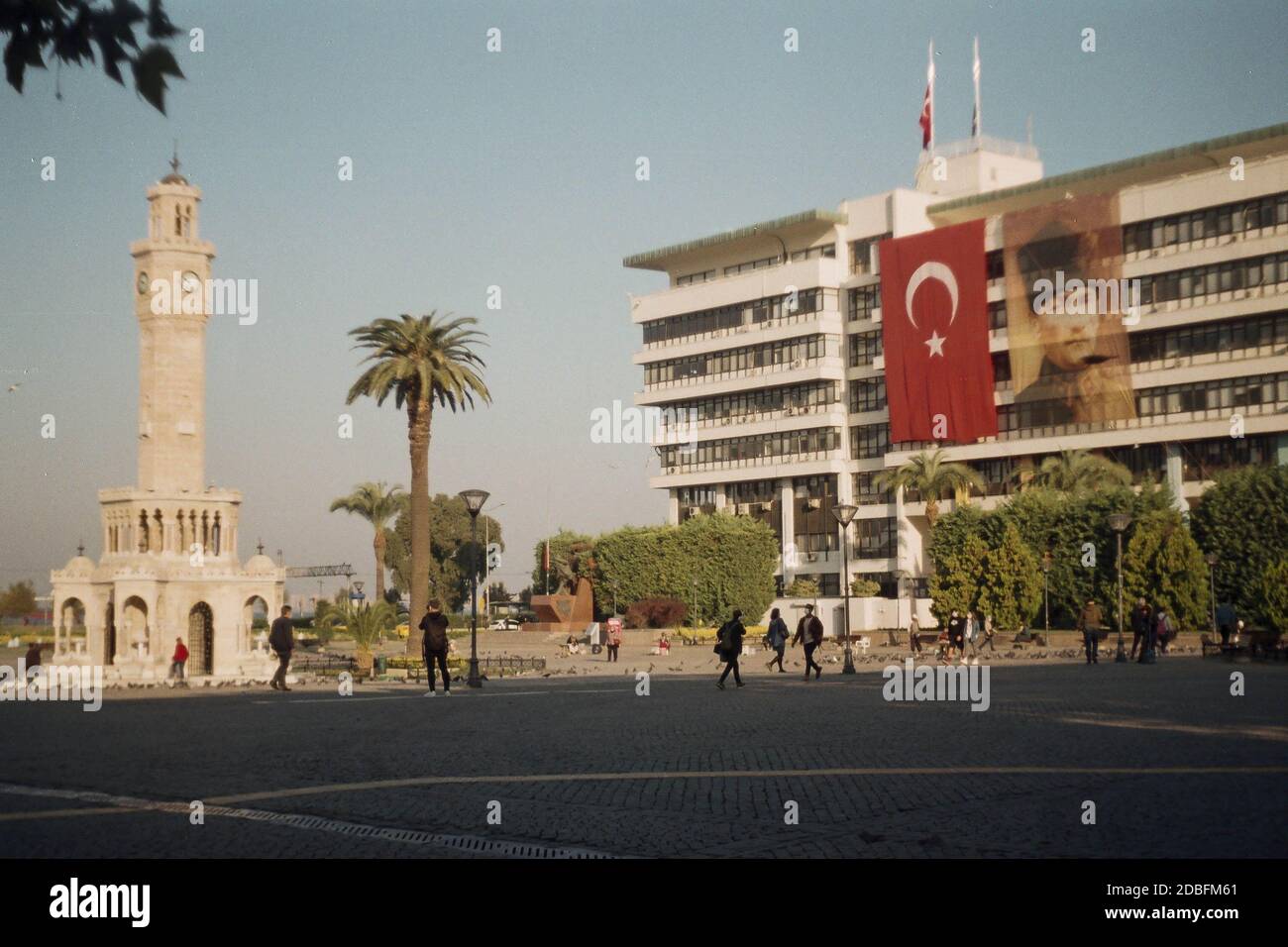 Izmir, Turchia - 16 novembre 2020 Film scan con qualche granello della Torre dell'Orologio di Konak con alcune persone con bandiera turca e poster Ataturk. Foto Stock