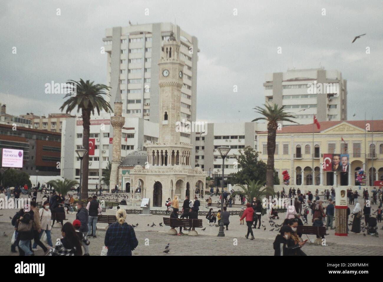 Izmir, Turchia - 16 novembre 2020 Film scan con qualche granello della Torre dell'Orologio di Konak con alcune persone con bandiera turca e poster Ataturk. Foto Stock