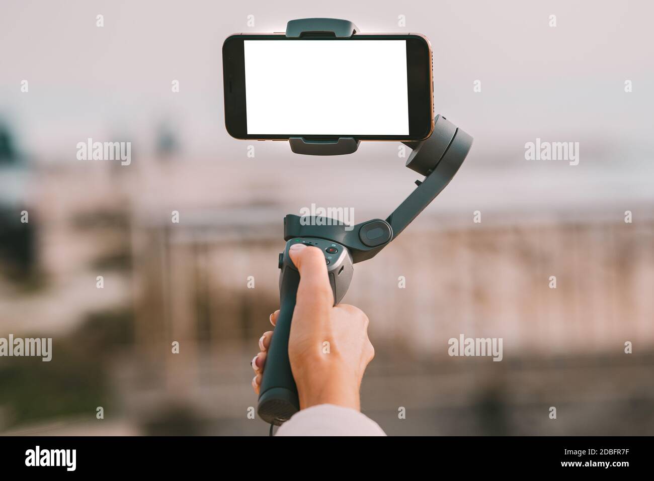 Mano donna con un gimbal per smartphone con schermo vuoto. Concetto di vlog e video blogging. Foto Stock