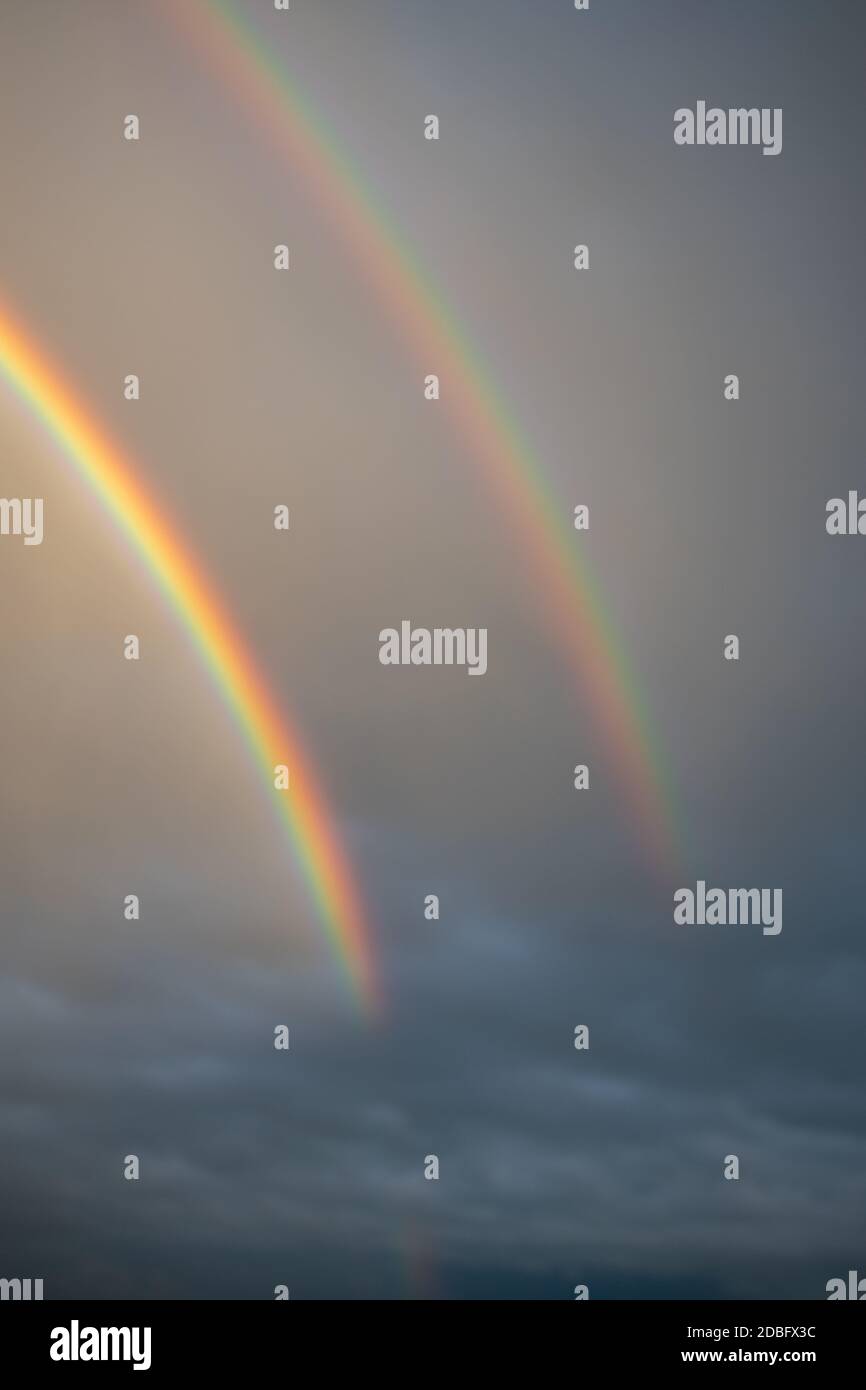 Arcobaleno visto attraverso la finestra bagnata con gocce d'acqua Foto Stock