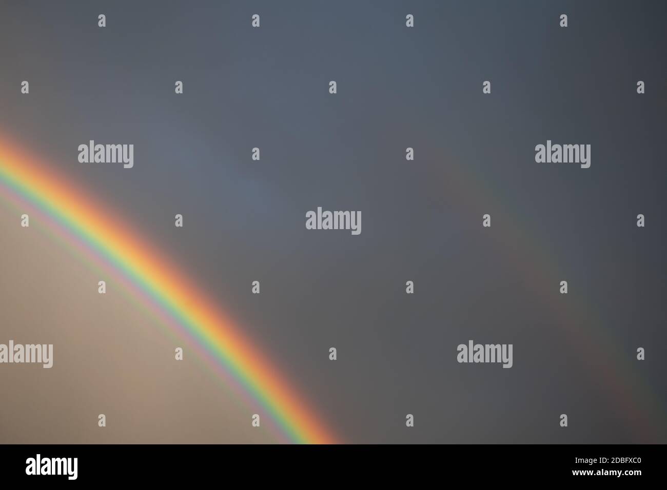 Arcobaleno visto attraverso la finestra bagnata con gocce d'acqua Foto Stock