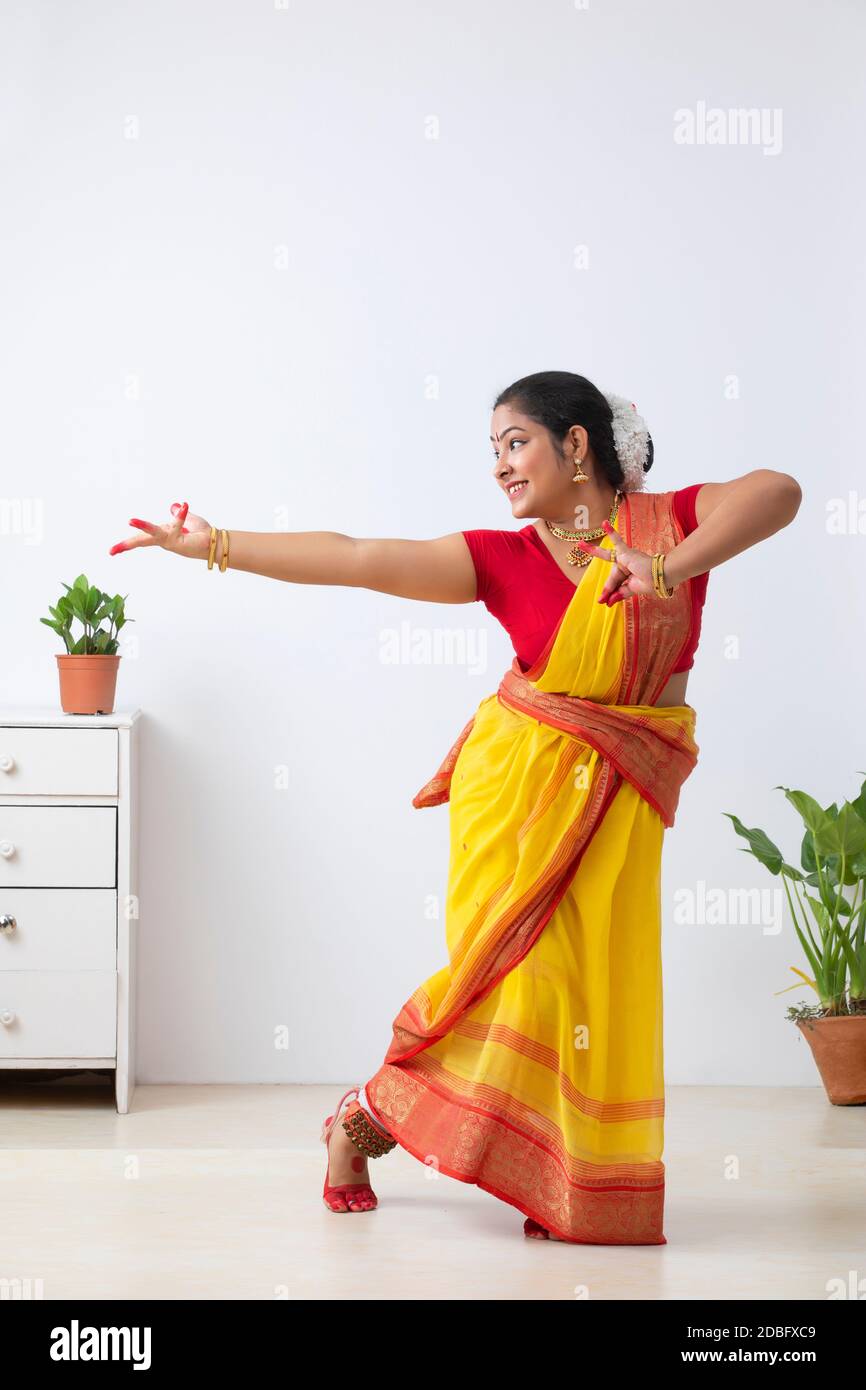 Ballerino Kuchipudi che pratica la postura della tillana mentre balla a casa Foto Stock