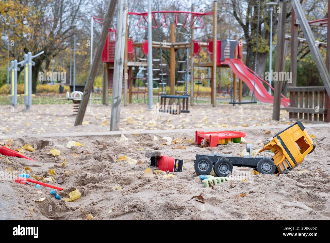 Parco giochi desertato in un parco cittadino con giocattoli per bambini rotti durante la chiusura COVID-19. Restrizioni di allontanamento sociale del virus Corona. Parcheggio vuoto. Foto Stock