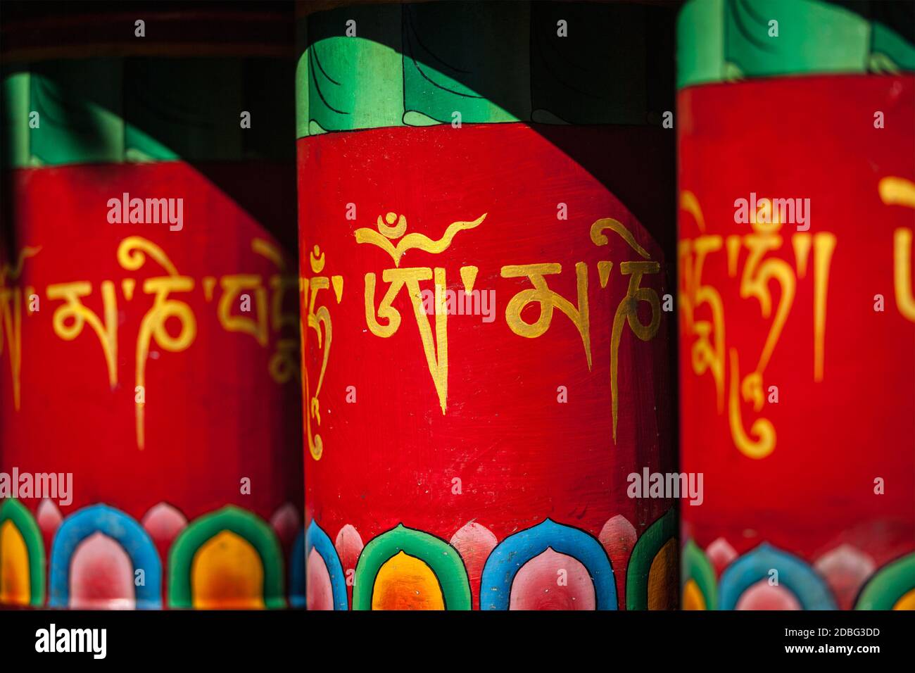 Ruote buddiste di preghiera con om mani padme hum (che significa che il gioiello è nel loto) mantra. Kora intorno al complesso di Tsuglagkhang. Mcleodganj, Prata di Himachal Foto Stock