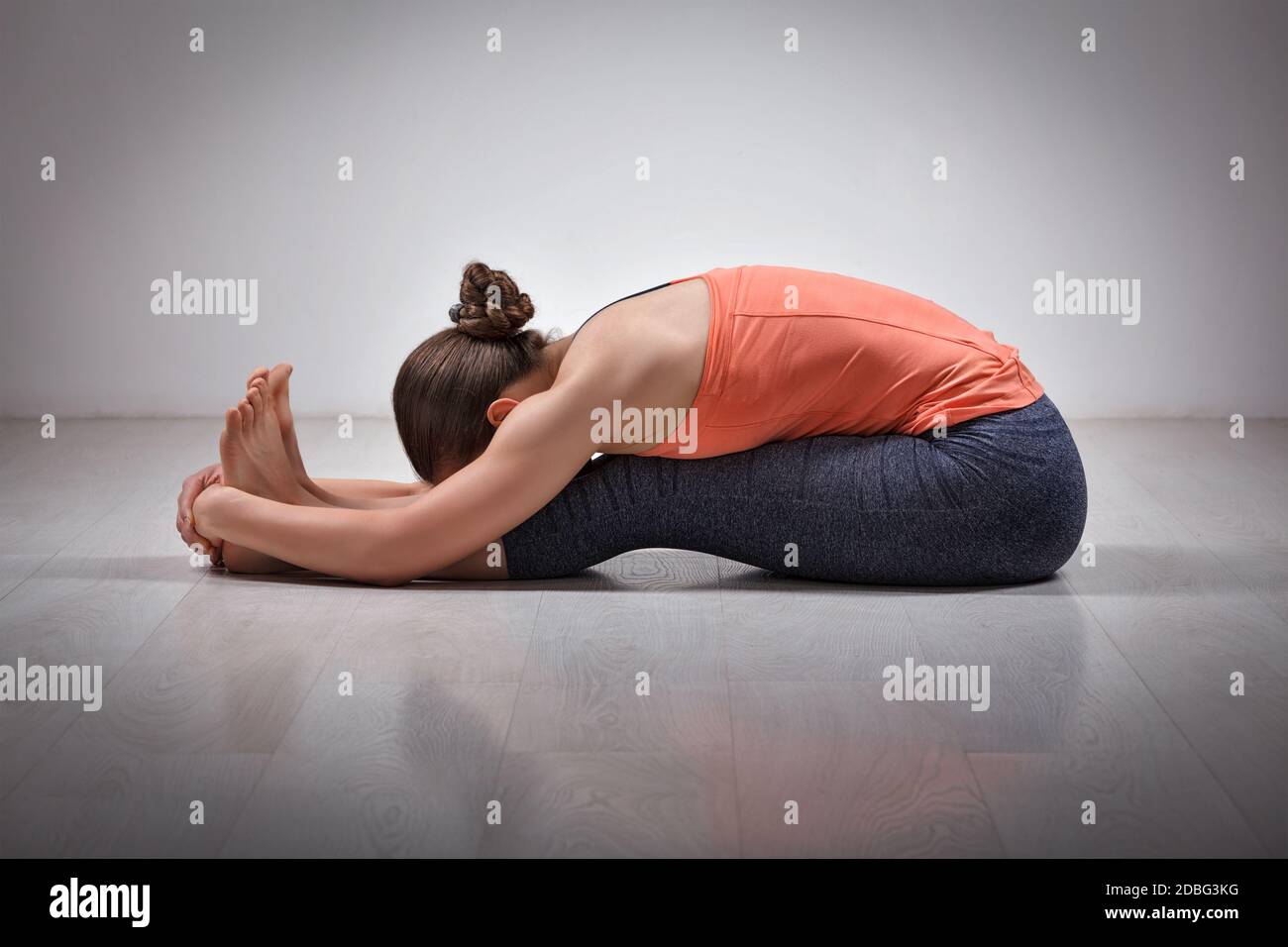 Sport fit donna pratica Ashtanga Vinyasa yoga schiena piegando asana Paschimottanasana - seduta curva in avanti Foto Stock