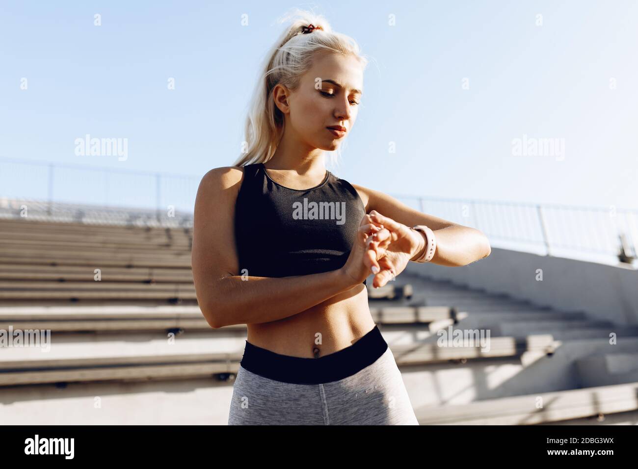 Giovane donna sportiva che controlla i progressi dell'orologio  intelligente, runner che guarda la fascia cardio orologio intelligente  all'aperto, sport, stile di vita sano Foto stock - Alamy