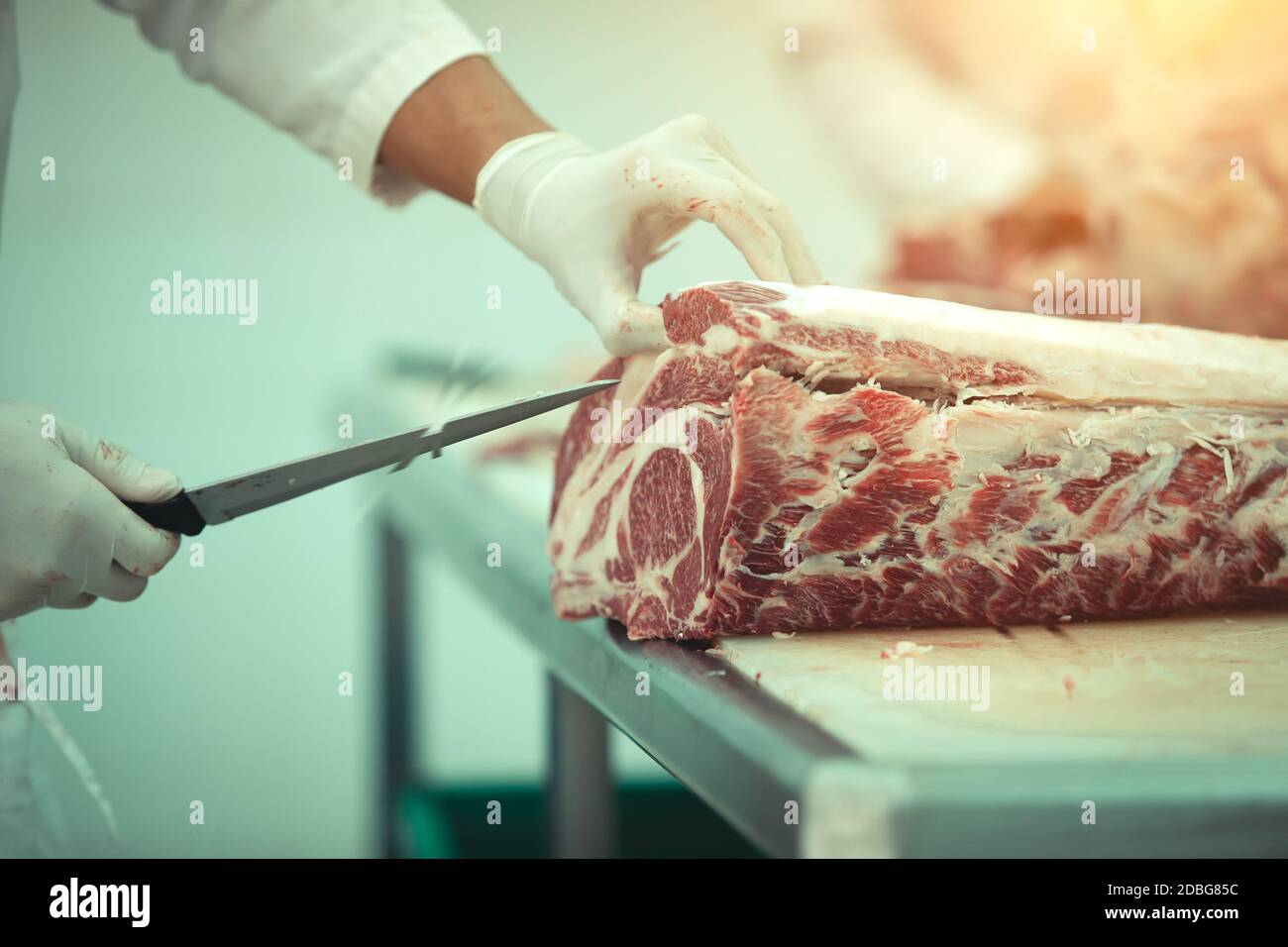 Il macellaio che taglia la carne di wagyu in un macello Foto Stock