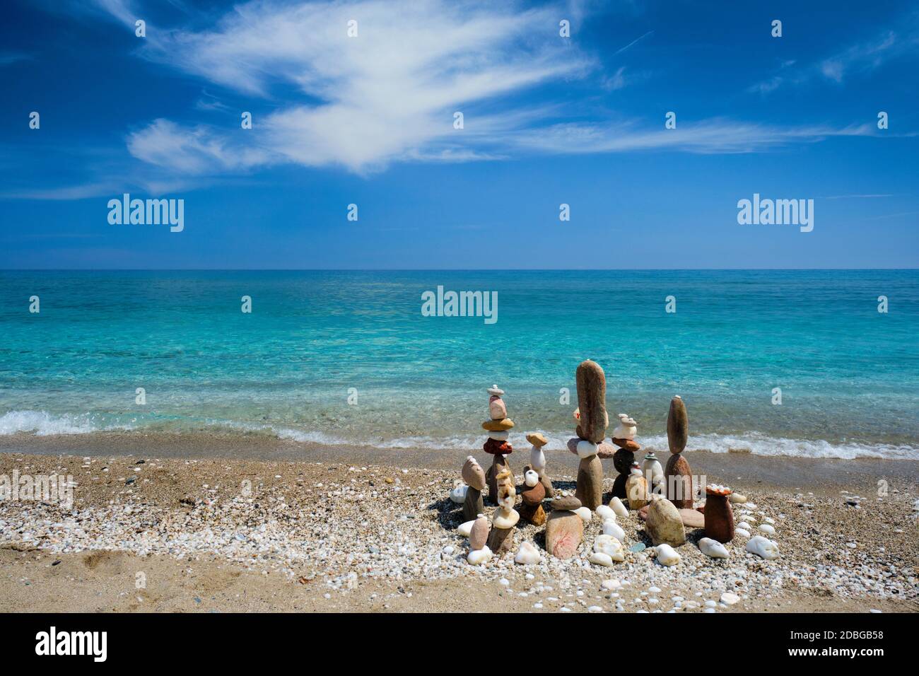 Concetto di equilibrio e armonia. Pietre ciottoli stack sulla spiaggia costa del mare blu nella natura. Arte meditativa di impilamento di pietra. Foto Stock