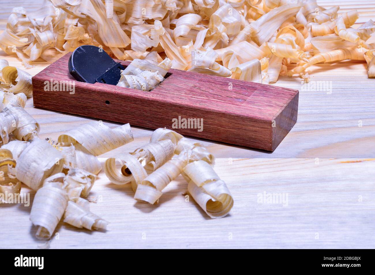 Piano di legno giapponese in rovere rosso con un mucchio di trucioli su una superficie di legno liscia. Sfondo. Foto Stock