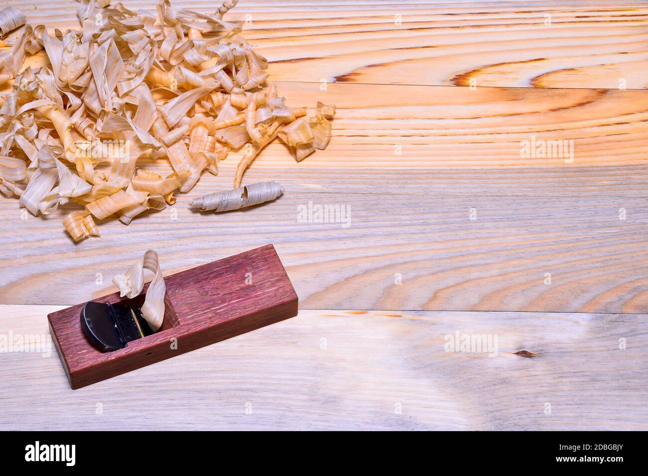 Piano di legno giapponese in rovere rosso con un mucchio di trucioli su una superficie di legno liscia. Sfondo. La vista dall'alto. Foto Stock