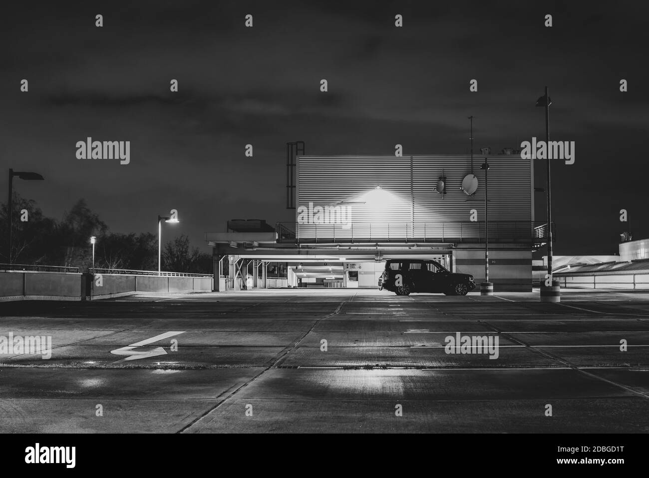 Un'auto su un ponte di parcheggio di notte, un'auto su un ponte di parcheggio, un ponte di parcheggio di notte, foto in bianco e nero Foto Stock