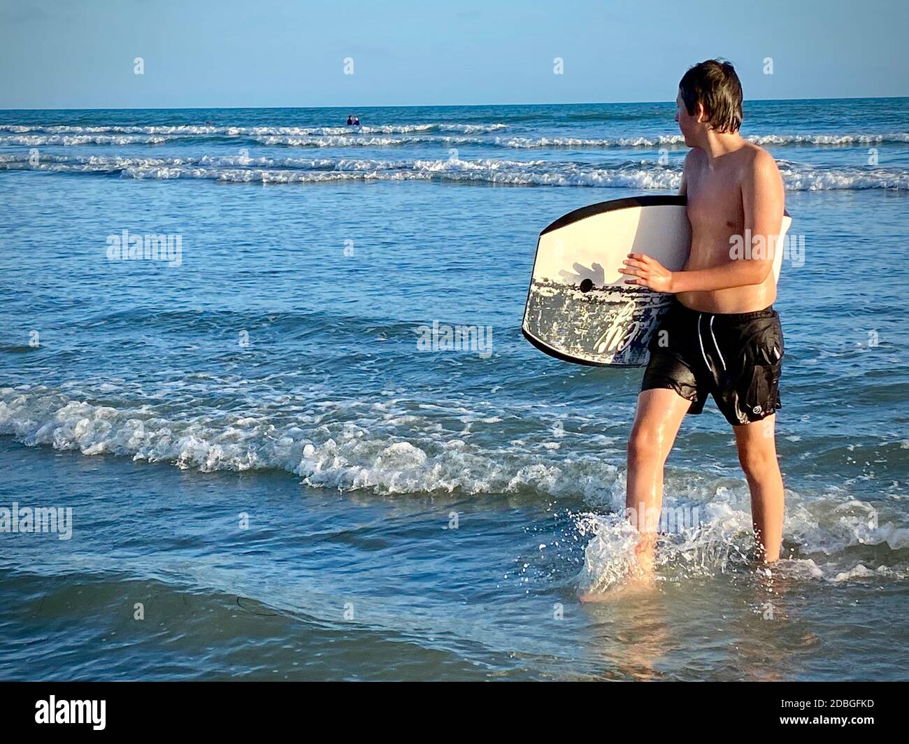 Giovane bodyboarder godendo il surf a East Wittering spiaggia in Il Regno Unito Foto Stock