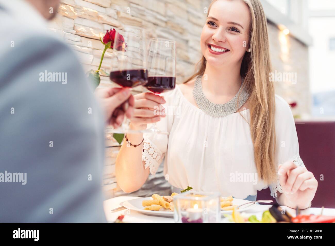 Tostatura in coppia con vino rosso in un romantico ristorante che si affaccia l'un l'altro Foto Stock
