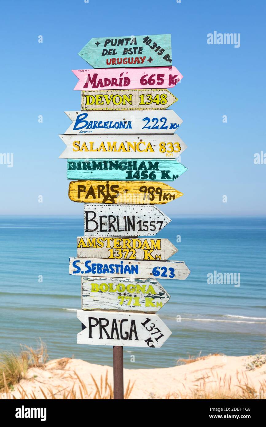 Indicazioni colorate sulla spiaggia per diversi luoghi del mondo. Concetto di viaggio. Foto Stock