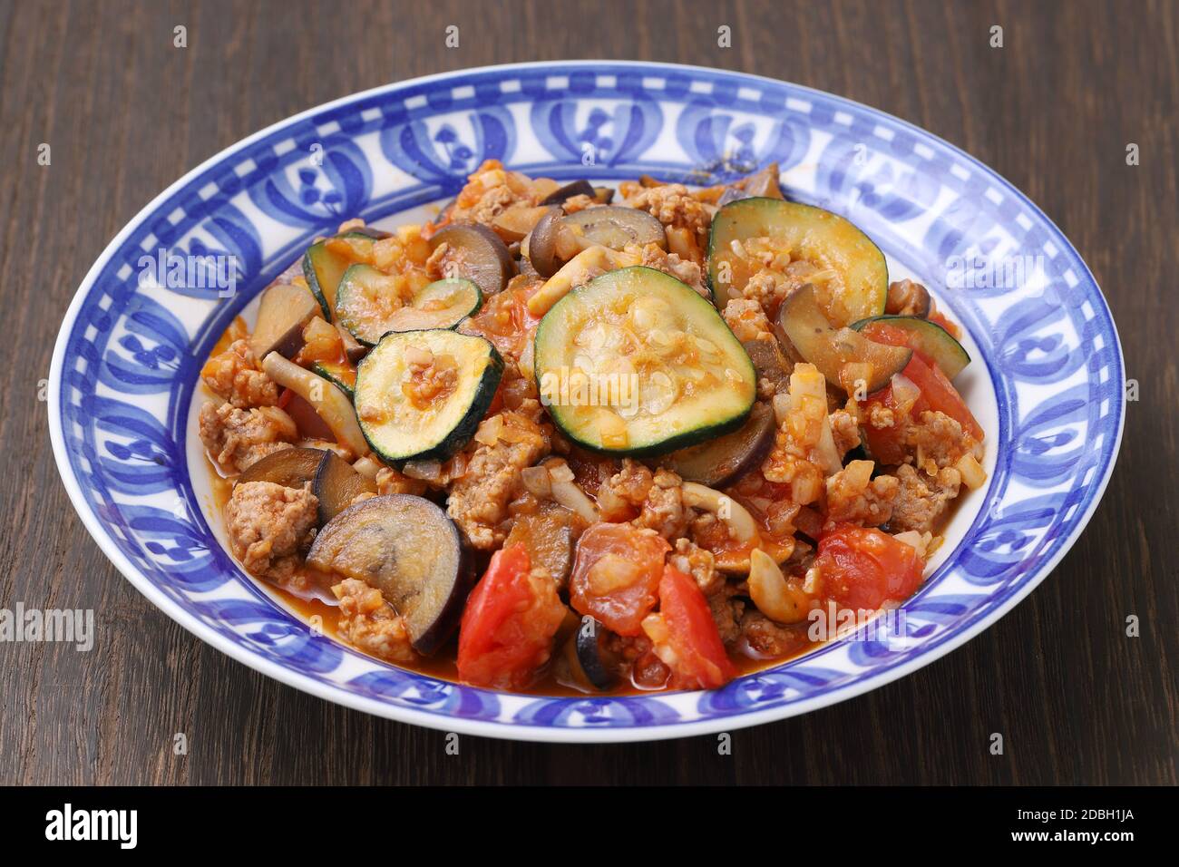 aggiungere la friggitrice di verdure con carne tritata in un piatto sul tavolo Foto Stock