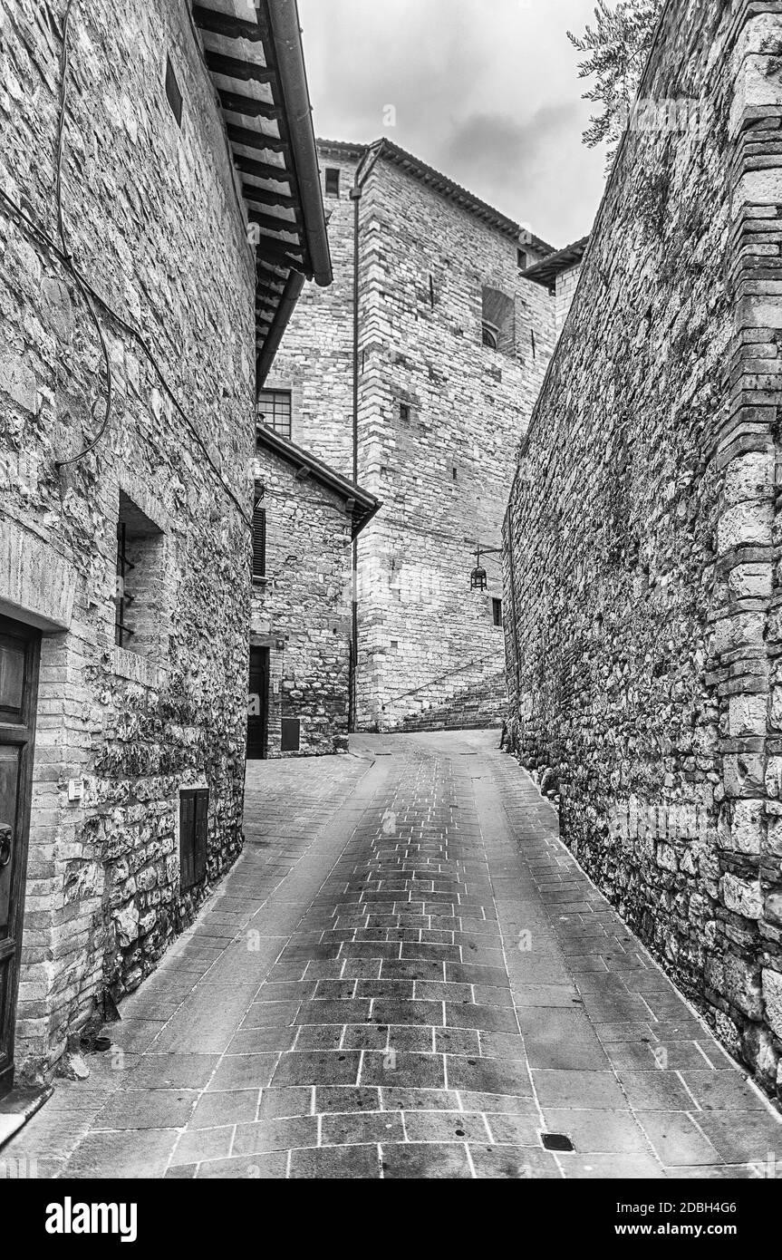 Passeggiando per le pittoresche e antiche strade di Assisi, una delle più belle città medievali in Italia centrale Foto Stock