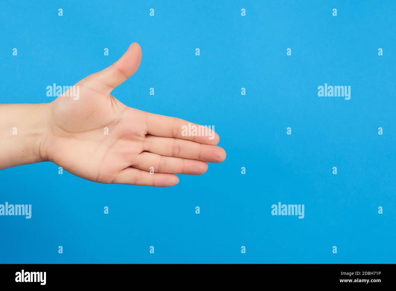 mano estensibile dell'uomo, mano aperta, parte del corpo su sfondo blu, primo piano Foto Stock