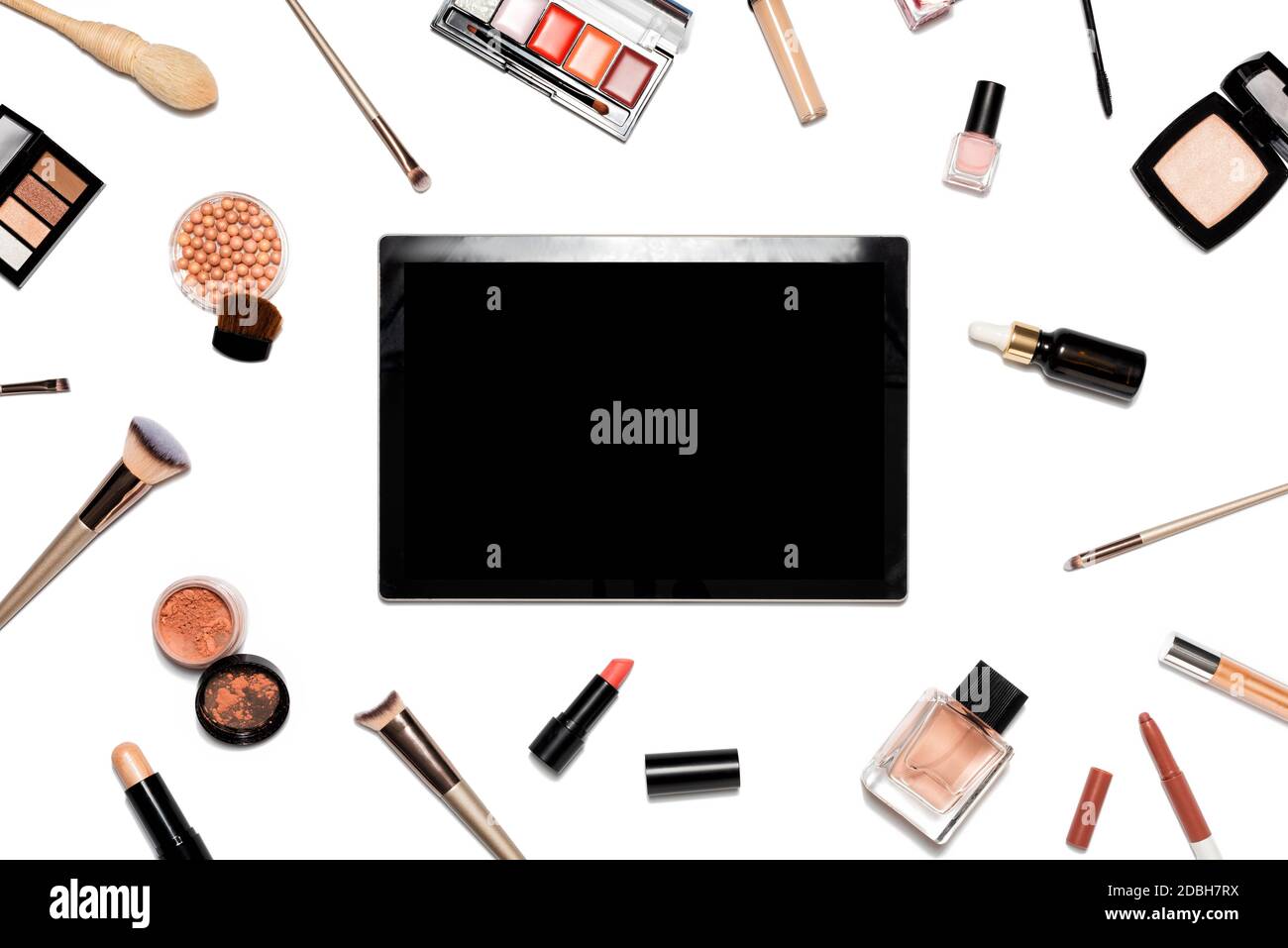 Cosmetici decorativi e strumenti per il trucco su sfondo bianco con tablet. Concetto di shopping online. Composizione cornice con spazio di copia. Posa piatta o via superiore Foto Stock