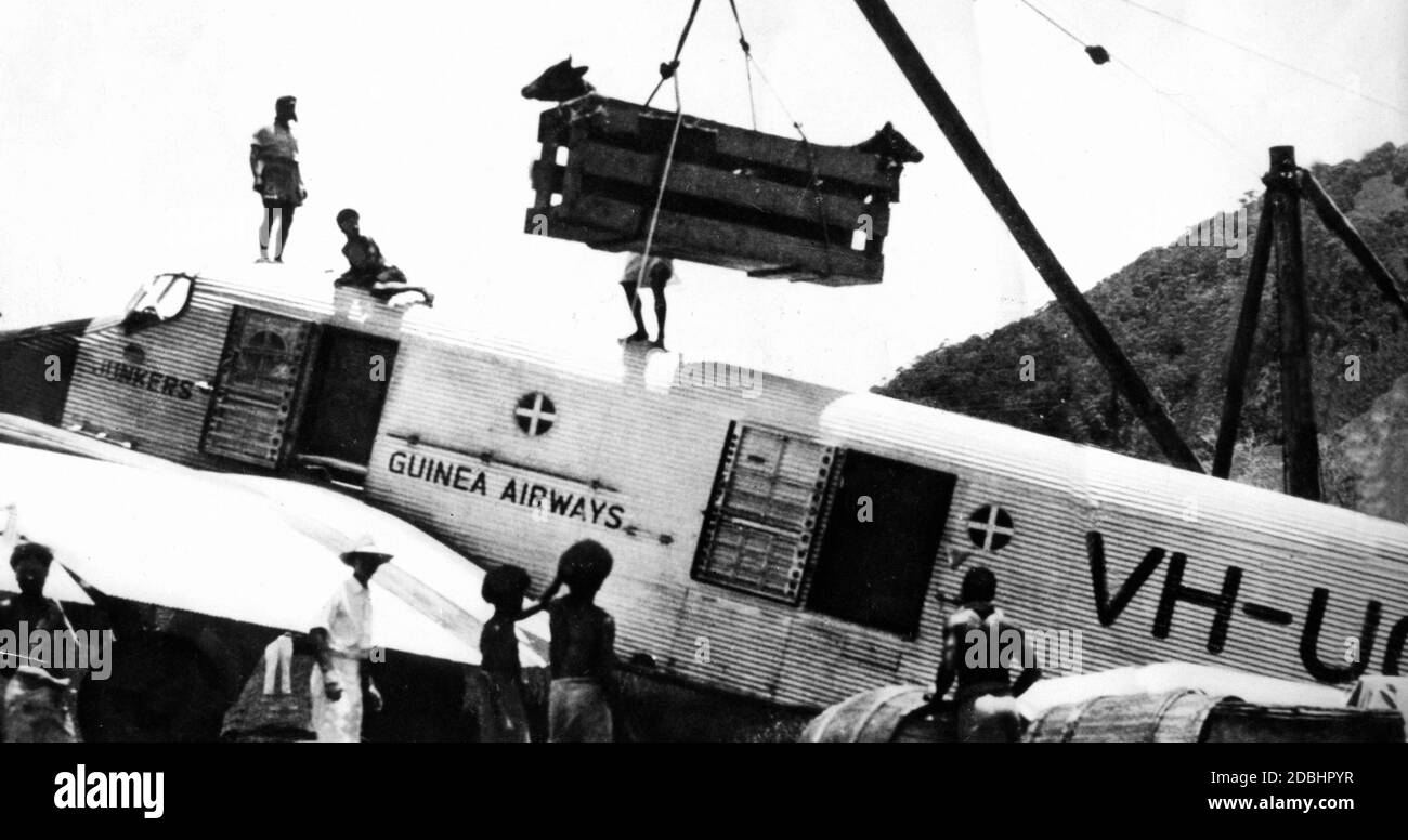 Nell'ex colonia tedesca della Nuova Guinea, le disposizioni per gli scavatori d'oro sono caricati su un aereo da tedeschi e locali per essere trasportati nei siti di scavo d'oro. Foto Stock