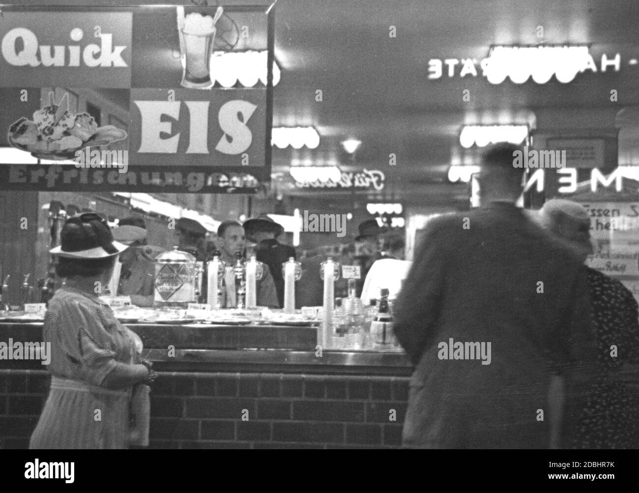 "Passers-by stand di fronte ad un bar sulla Joachimsthaler Strasse a Berlino-Charlottenburg, che pubblicizza con ''Quick EIS Erfrischungen''. La fotografia è stata scattata negli anni '30.' Foto Stock
