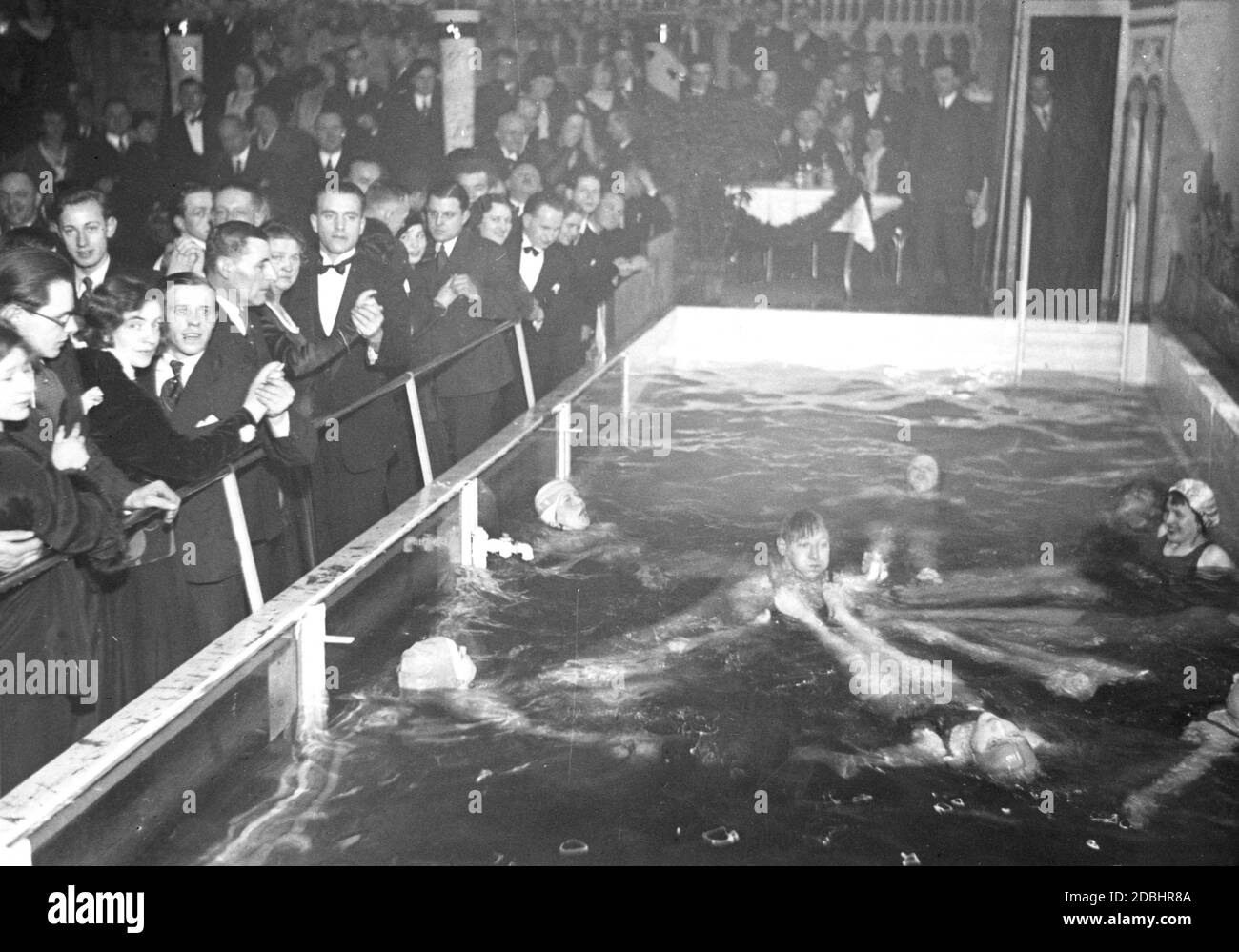 "Nel nuovo Tanzpalast ("Palazzo della Danza") di Berlino-Mitte, l'ex Altes Ballhaus di Joachimstrasse, è stata costruita una piscina come attrazione, dove donne e un uomo stanno facendo un bagno. Sulla sinistra, gli ospiti guardano dalla pista da ballo. La tendenza del bagno nei palazzi da ballo è stata rilevata da Parigi. La foto è stata scattata nel 1931." Foto Stock