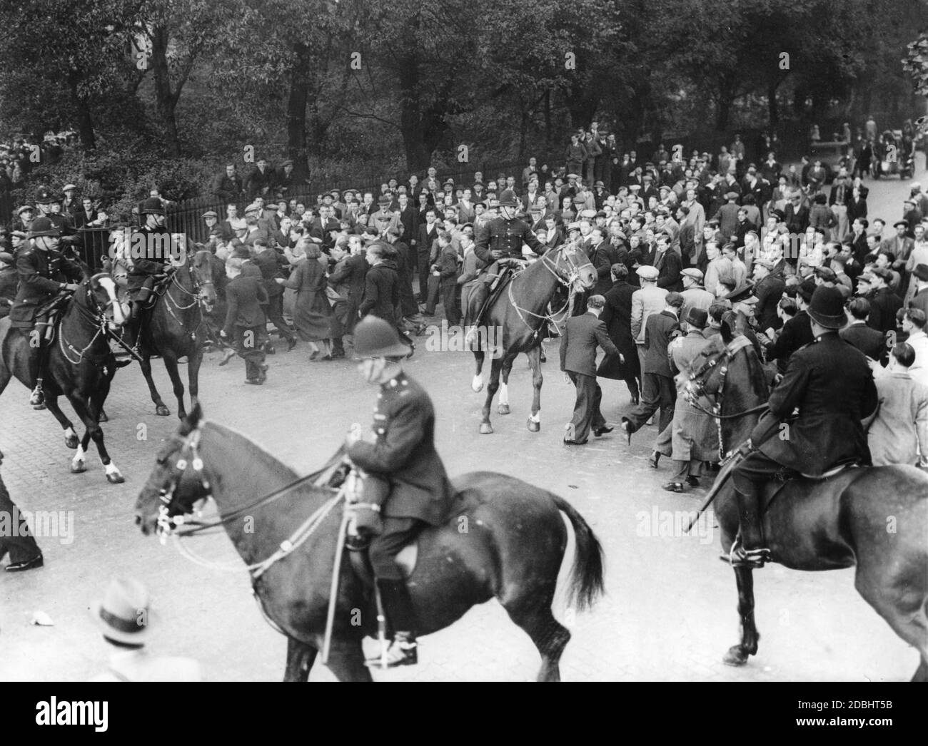 I poliziotti montati cercano di disperdere una folla di manifestanti nel Victoria Park di Londra. Foto Stock