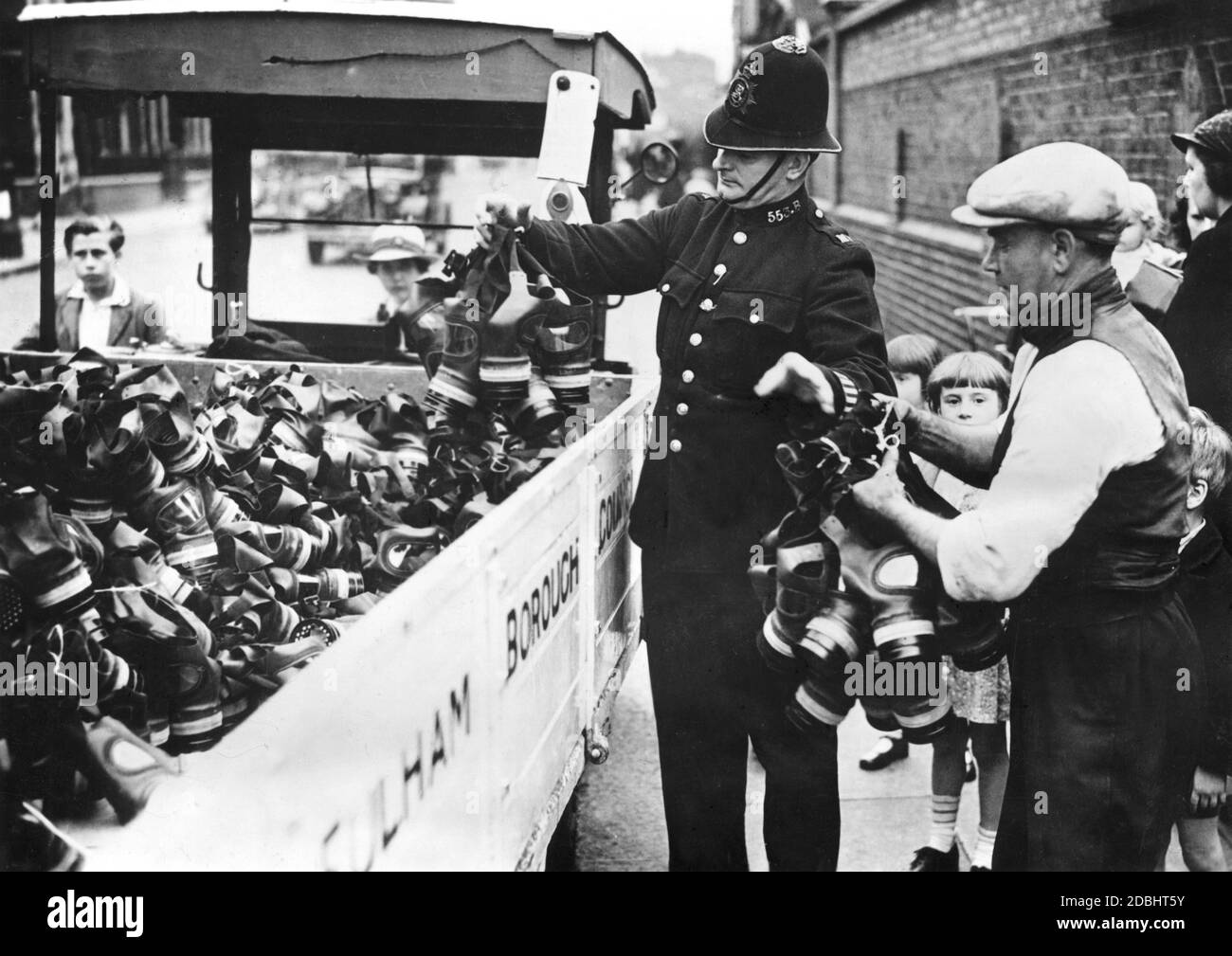 Un poliziotto distribuisce maschere a gas alla popolazione nel distretto londinese di Fulham. Foto Stock