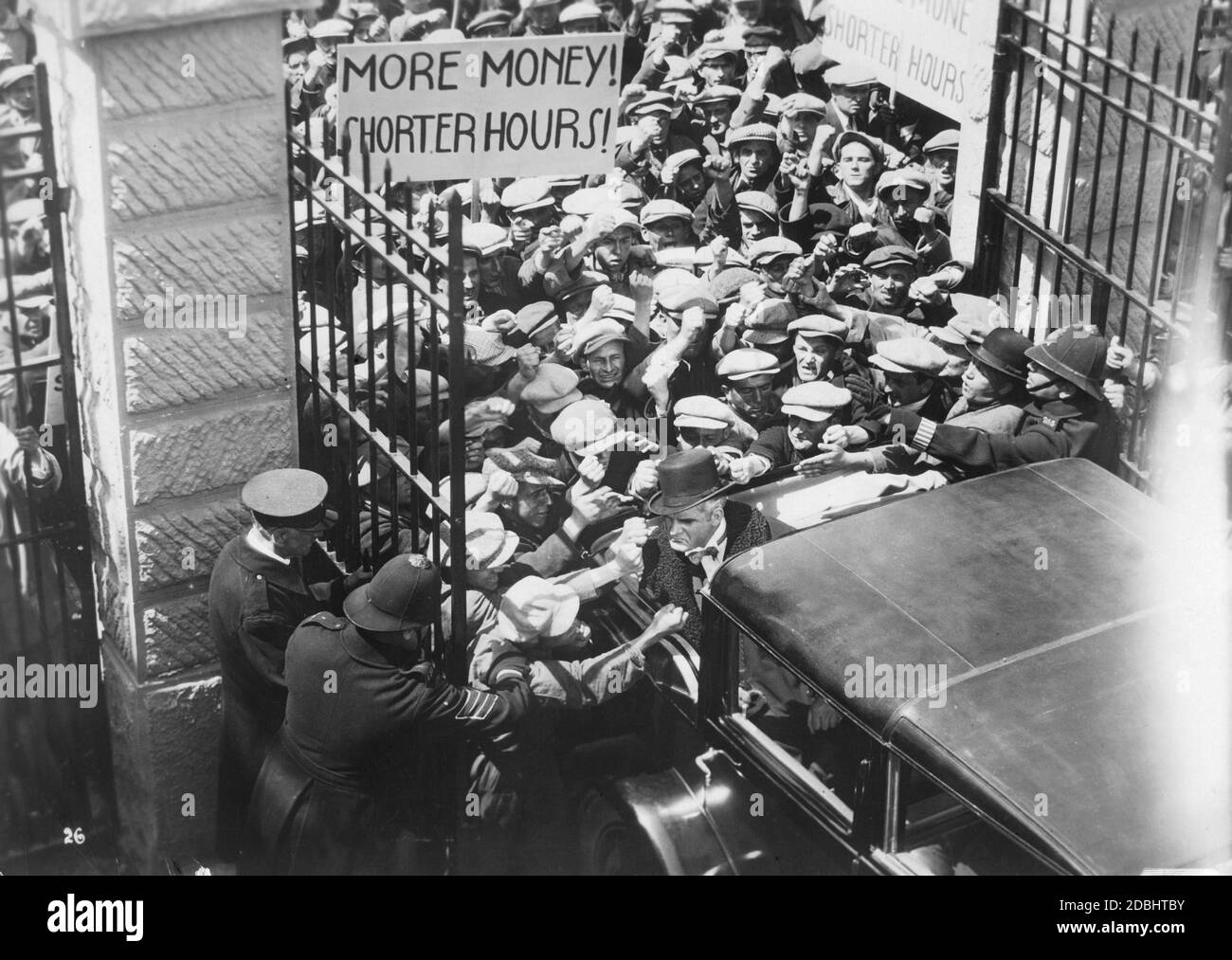 Un gruppo di lavoratori che colpiscono il proprietario della fabbrica, che viene guidato alla fabbrica a bordo di un'auto aperta. Con un poster richiedono salari più elevati e orari di lavoro più brevi. (foto non datata) Foto Stock