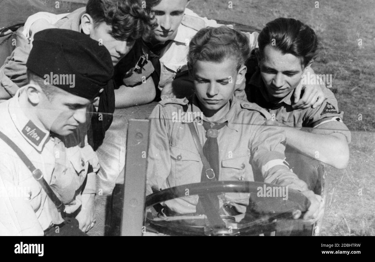 4 membri del Motor Hitler Youth siedono in un Kuebelwagen. Uno di questi è dietro la ruota e sul sedile del passeggero è un uomo NSKK. Foto Stock