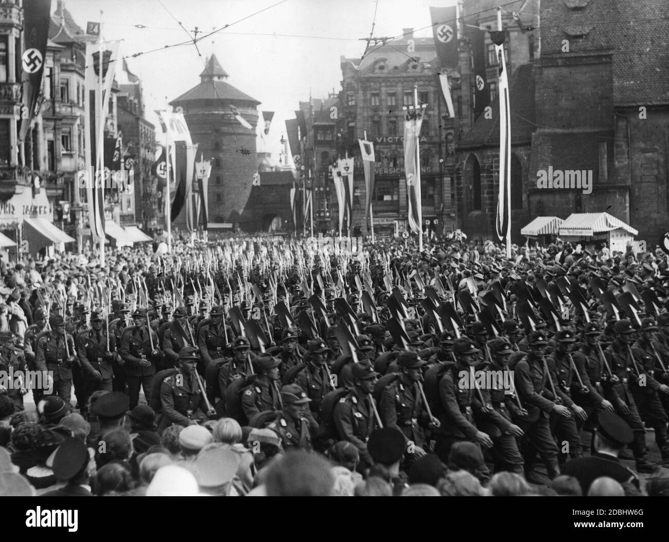 Nella Koenigstrasse di Norimberga, decorata con bandiere di swastika, le formazioni del Servizio laburista Reich marciano verso la piazza principale del mercato durante il Congresso del Partito nazista. Sullo sfondo è il Koenigstor. Foto Stock