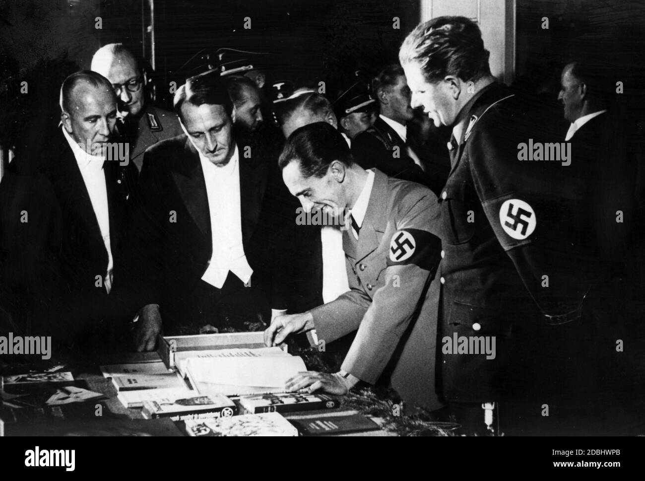 "Joseph Goebbels si fa sorridere attraverso il suo libro, che gli è stato presentato in occasione della settimana del Libro tedesco a Weimar. Il libro contiene voci di 67 autori tedeschi. In primo piano è il presidente della Reichsschrifttumskammer (''Reich Chamber of Writers'') Hanns Johst.' Foto Stock