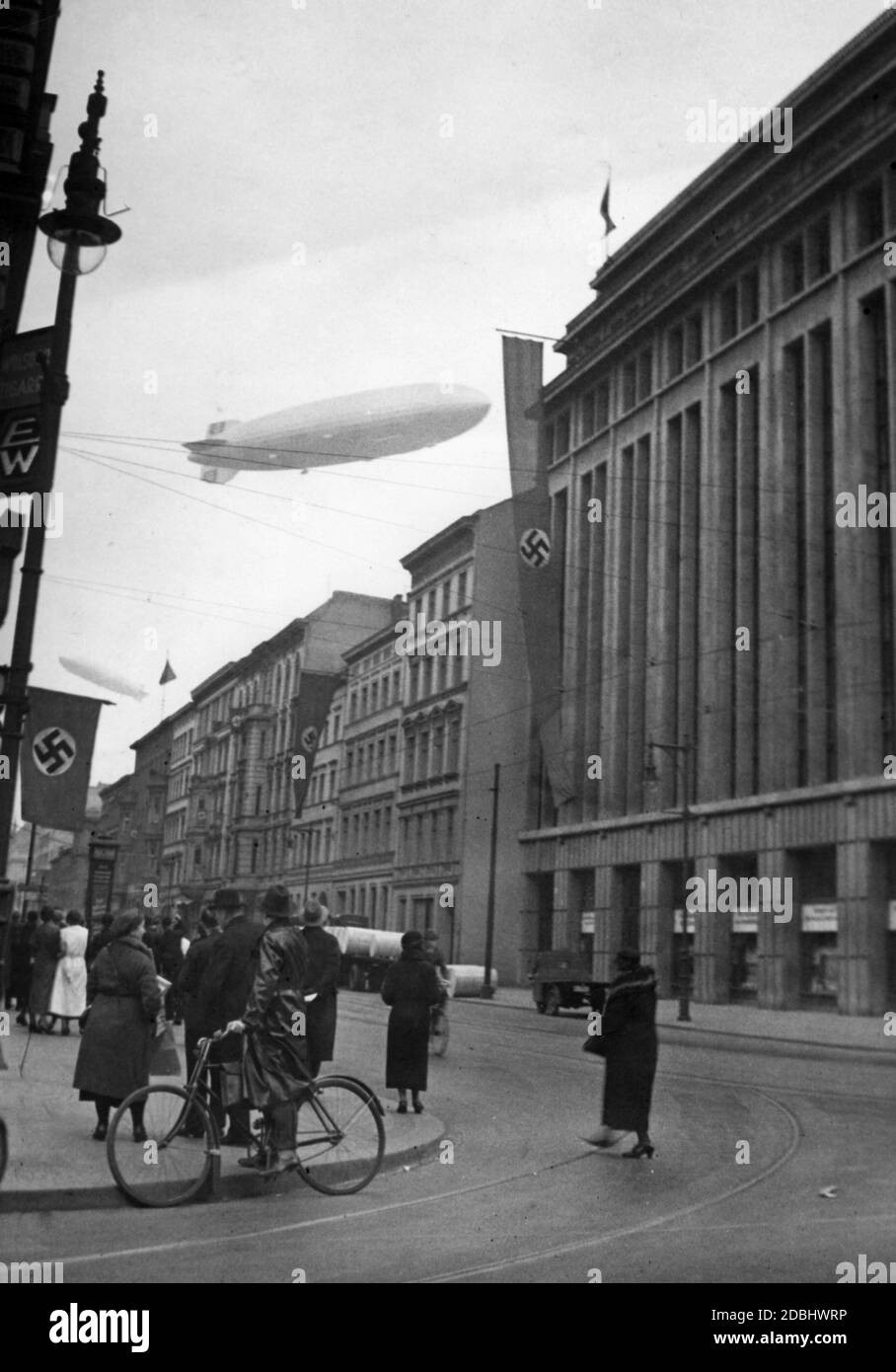 'Scena di treet a Berlino con le navi LZ 129 ''Hindenburg'' e LZ 127 ''Graf Zeppelin'' sul cielo.' Foto Stock