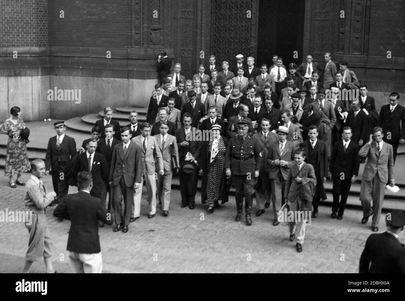 Gli studenti di scambio inglese lasciano il municipio di Berlino dopo una reception. Nella parte anteriore, al centro, in uniforme di partito, il commissario di Stato Hans Meinhausen, capo dell'ufficio di cambio, insieme al consigliere della scuola comunale Kausle (a sinistra). Foto Stock