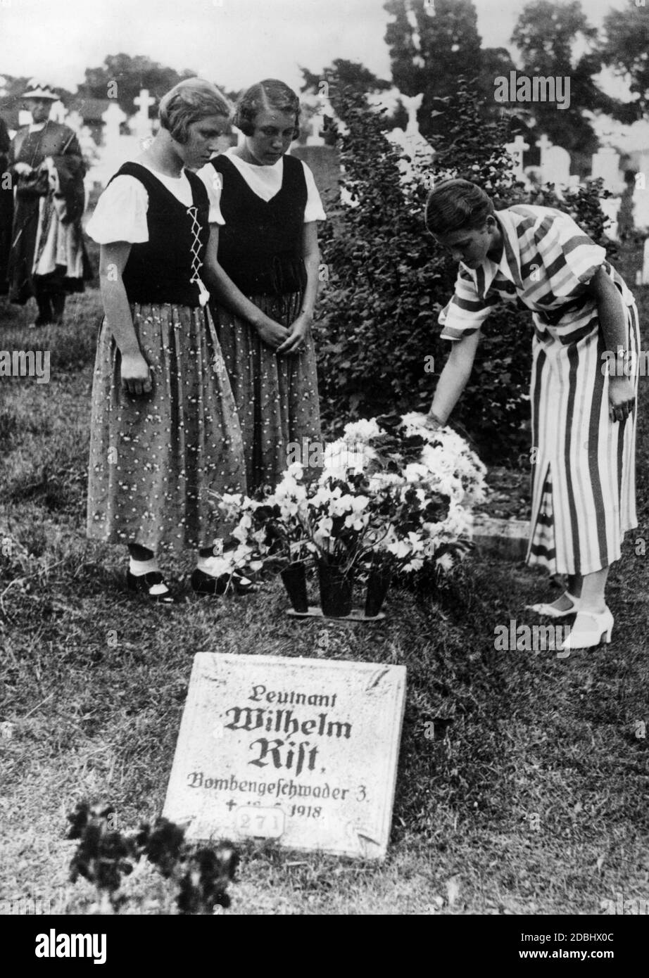 Durante un viaggio di studio, tre ragazze di un gruppo di studentesse tedesche decorano la tomba del tenente tedesco dell'aeronautica Wilhelm List vicino Clacton, Essex. Foto Stock