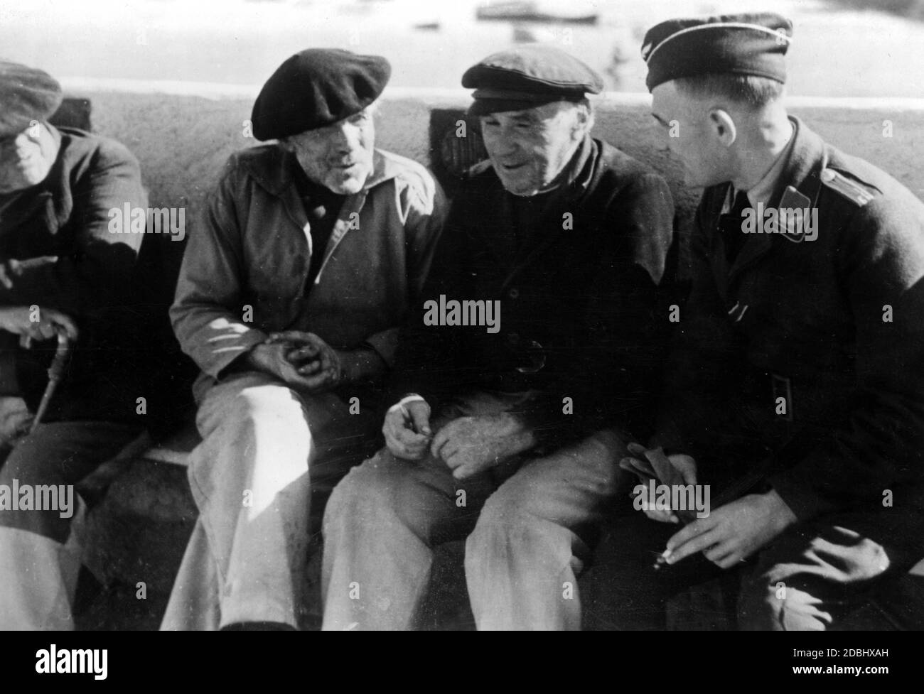 Due pescatori bretoni parlano con un ufficiale tedesco. Foto Stock