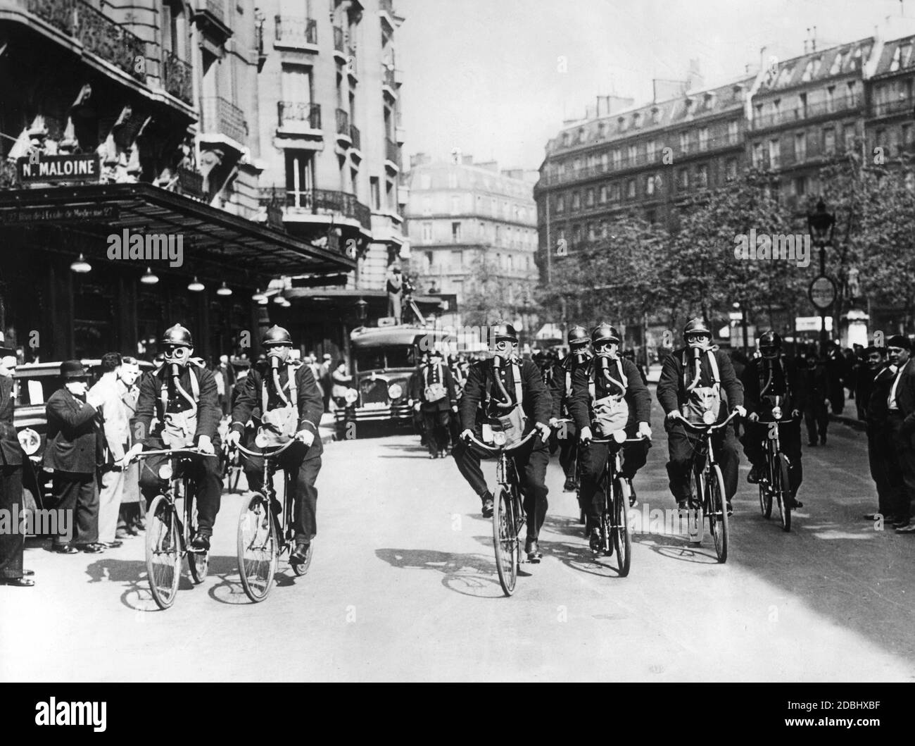 I membri della squadra di soccorso della polizia di Parigi su biciclette con maschere a gas durante un esercizio di protezione respiratoria. Foto Stock