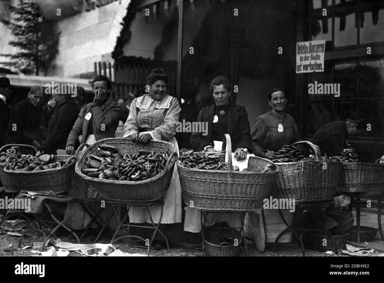 Le donne offrono pretzel in vendita di fronte ad una tenda di birra (foto non datata). Foto Stock