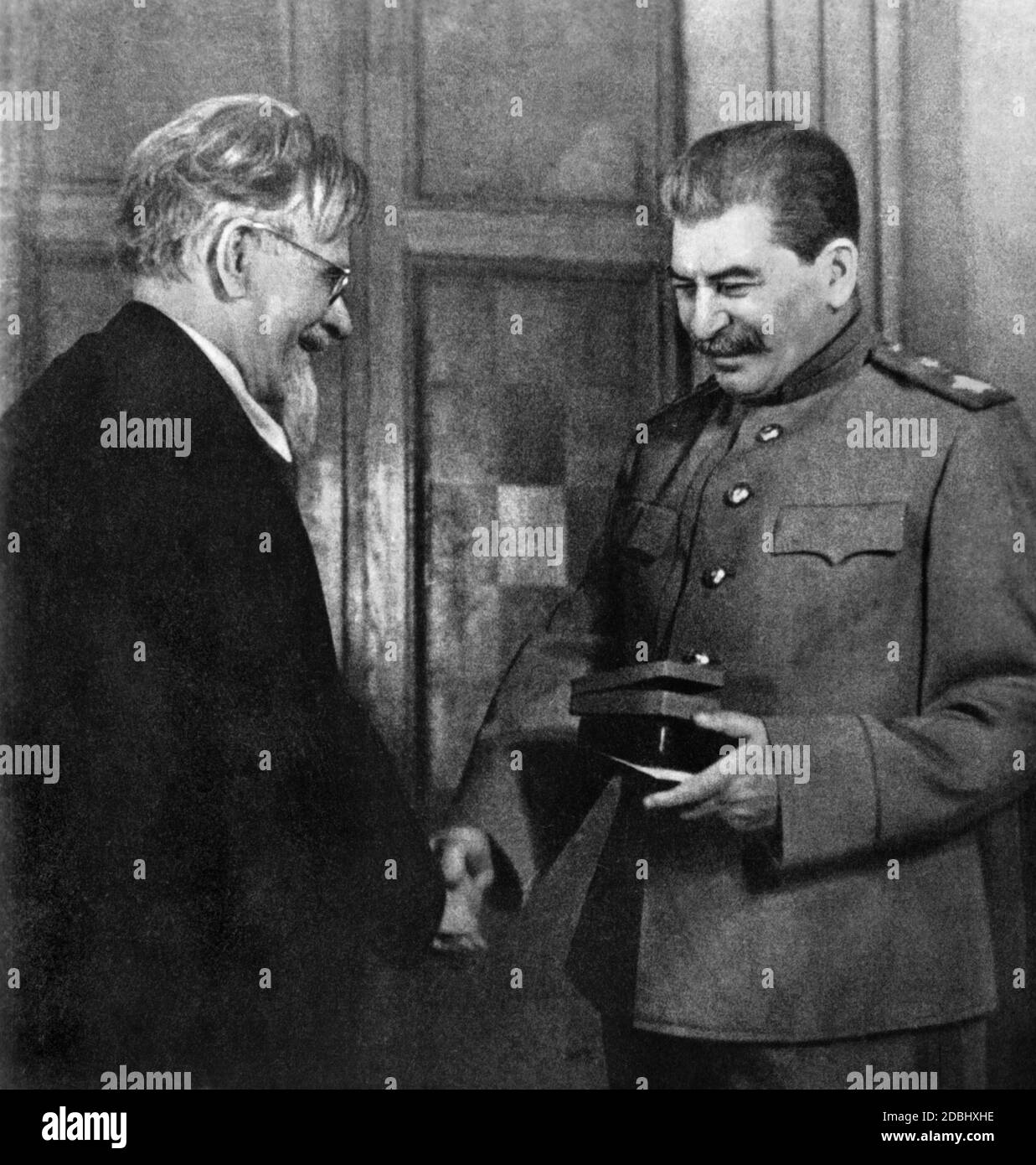 Il capo di stato ufficiale dell'Unione Sovietica, Mikhail Ivanovich Kalinin, con il dittatore Joseph V. Stalin. Kalinin presenta a Stalin una medaglia di vittoria per l'eccellente organizzazione della repressione dell'esercito tedesco. Foto Stock