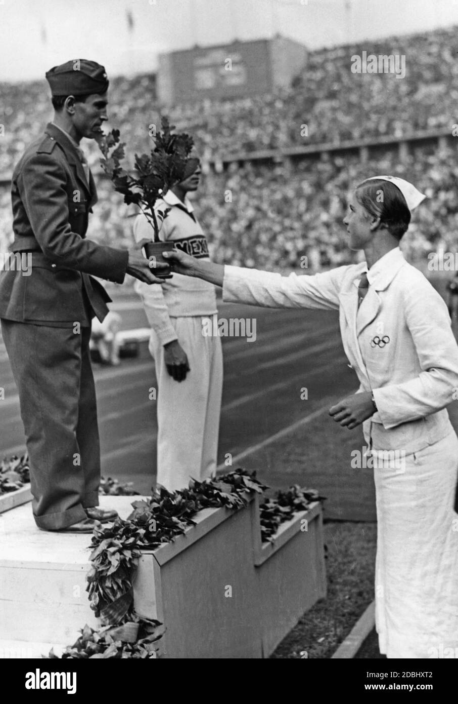 Cerimonia di premiazione del Bantamweight: Ulderico Serbo (Italia) seguito da Fidel Ortiz (Messico, 3° posto). Un assistente passa l'atleta italiano un albero di quercia. Foto Stock