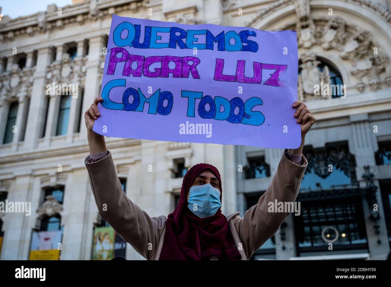 Madrid, Spagna. 17 Nov 2020. Una donna che porta un cartello con la scritta "vogliamo pagare l'elettricità come tutti gli altri". Vicini della protesta Cañada Real di fronte al Consiglio comunale di Madrid per chiedere una soluzione per i tagli di potere nella baraccopoli. La polizia nazionale ha effettuato diverse incursioni contro le piantagioni di marijuana a la Cañada e ha richiesto più di mille piante. Queste strutture potrebbero trovarsi dietro ad allacciamenti illegali rilevati dalla società elettrica che sovraccarichi la rete. Credit: Marcos del Mazo/Alamy Live News Foto Stock