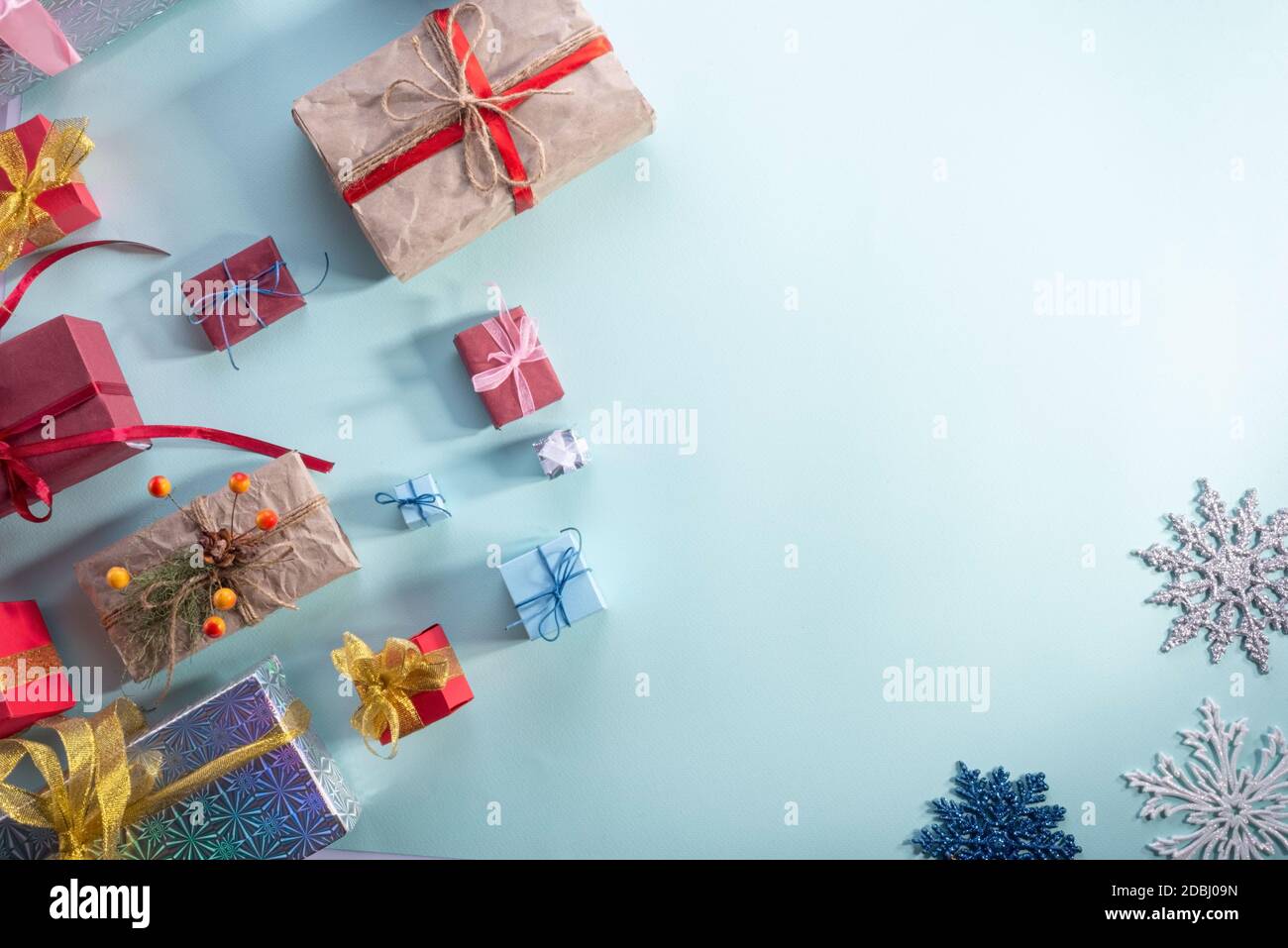 Vista dall'alto, tanti regali di Natale su sfondo blu. New Year flatlay bei regali in confezione d'oro e palline di Natale su sfondo blu Foto Stock