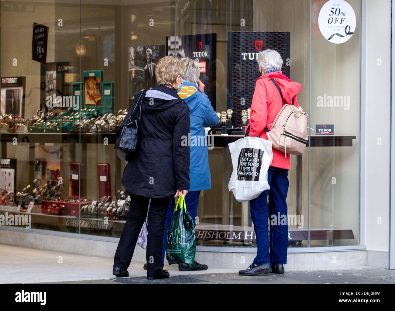 Dundee, Tayside, Scozia, Regno Unito. 17 Nov 2020. Notizie del Regno Unito Covid-19 Lockdown. Le persone che camminano per le strade di Dundee con pochi negozi di abbigliamento essenziali aperti dal livello 3 più rigoroso Covid-19 Lockdown restrizione è stato imposto. Tre donne anziane sono consapevoli delle linee guida per le distanze sociali e l'uso di maschere in piedi al di fuori della Chisholm Hunter Jewellers durante l'ultimo minuto di shopping natalizio nel centro della città in un pomeriggio di novembre mite e soleggiato. Credit: Dundee Photographics/Alamy Live News Foto Stock