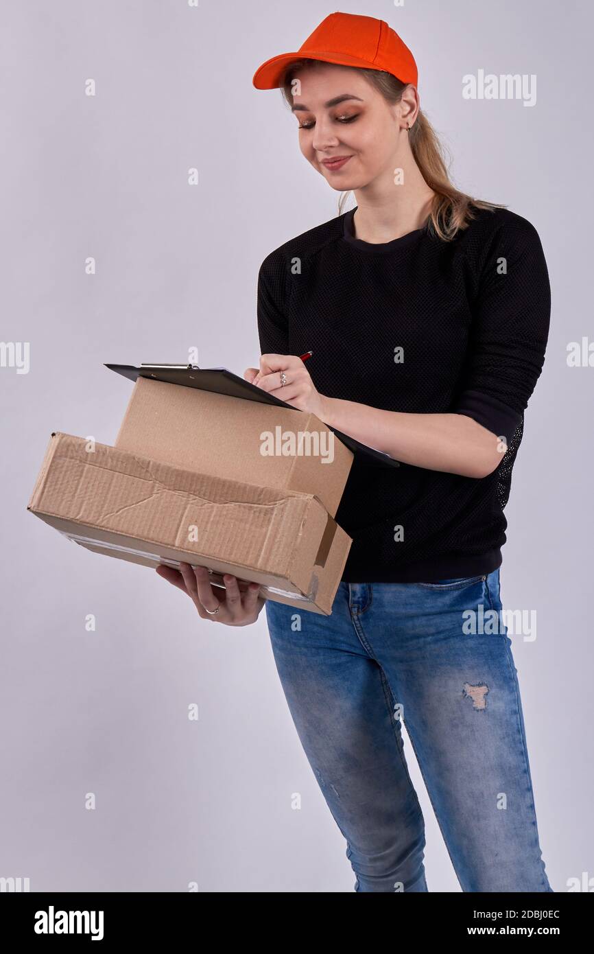 Sorridente corriere femminile sta firmando documenti. Foto Stock