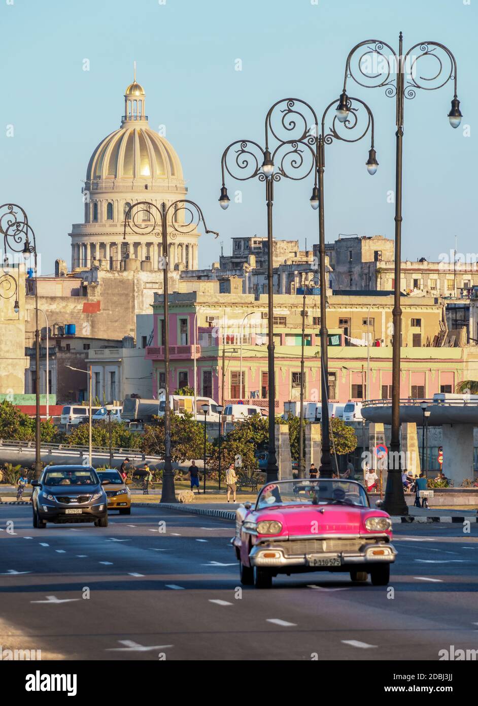 Auto d'epoca a El Malecon, Centro Habana e El Capitolio al tramonto, l'Avana, la provincia di Habana, Cuba, Indie Occidentali, America Centrale Foto Stock