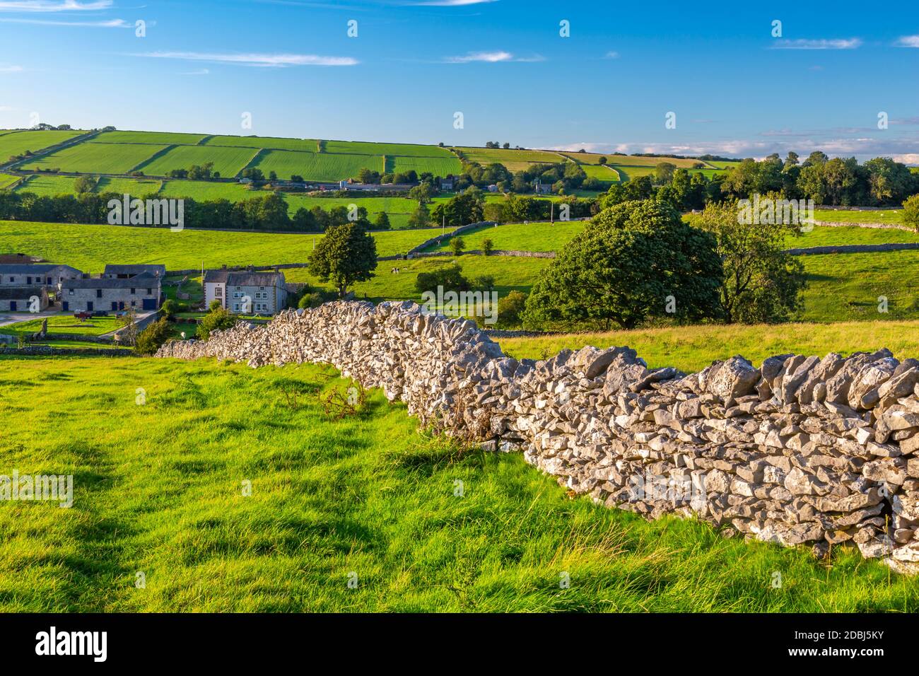 Vista delle pareti in pietra a secco e sul villaggio di Haddon, Peak District National Park, Derbyshire, Inghilterra, Regno Unito, Europa Foto Stock