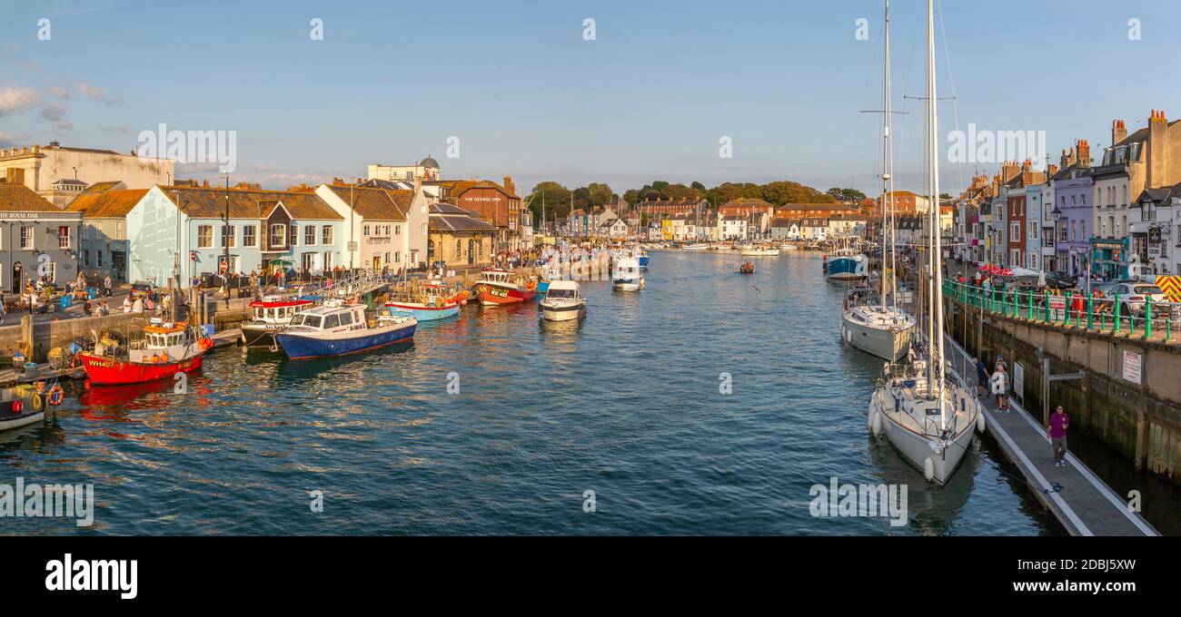 Vista delle barche nel Porto Vecchio e le case sul molo al tramonto, Weymouth, Dorset, Inghilterra, Regno Unito, Europa Foto Stock