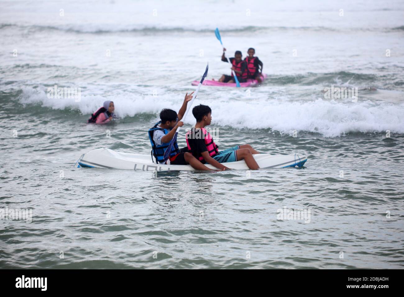 Yogyakarta, Indonesia - 30 ottobre 2020 : i turisti si godono una vacanza sulla spiaggia giocando a bordo di una barca Foto Stock