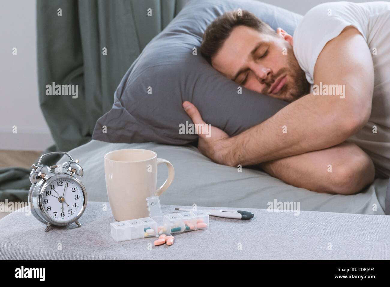 Uomo che riposa nel letto dopo aver preso le pillole addormentate in Camera da letto Foto Stock