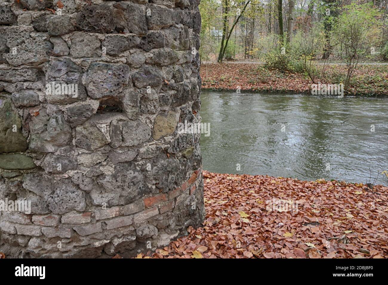 Vecchio posto di guardia vicino a un canale d'acqua a Monaco Englischer Garten in autunno, bellissimo parco nel cuore della città Foto Stock