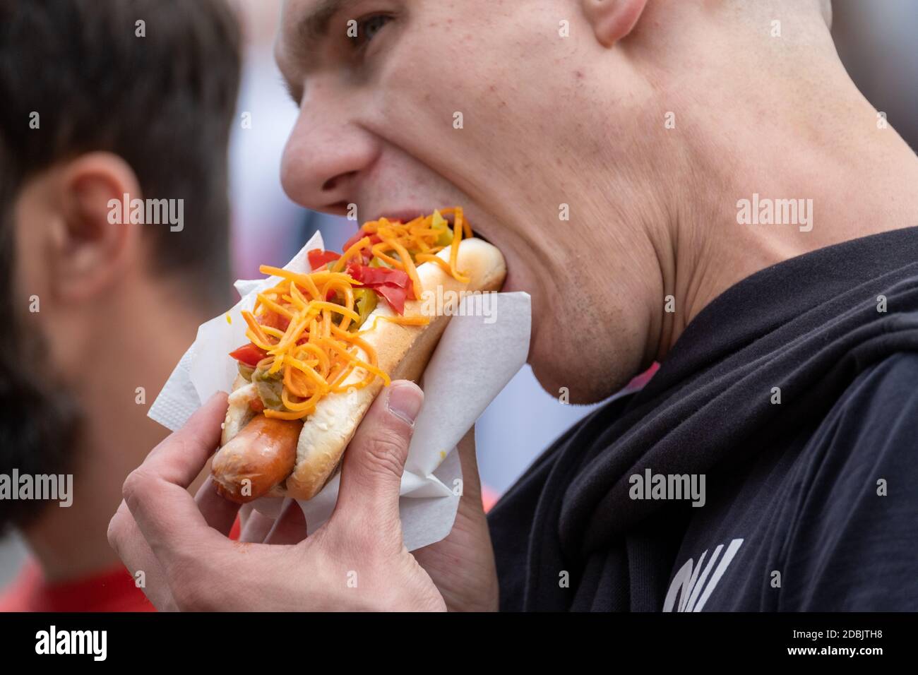 Uomo che mangia delizioso hot dog Foto Stock